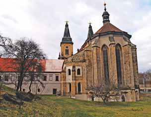 Ze zahrady kostela lze spatřit presbytář se sakristií
